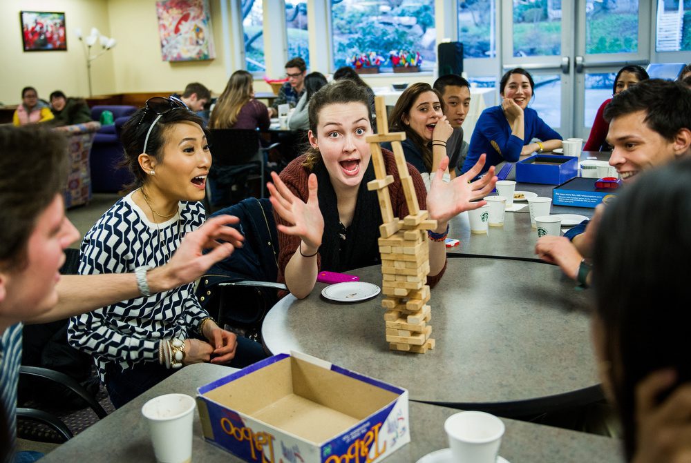 Madeline McGill (COM '16) reacts during a game of Jenga  as Sandra Yoon (COM'16) looks on during a welcome back gathering at GSU on Monday, January 14, 2014.  Photo by Jacke Ricciardi for Boston University Photography
