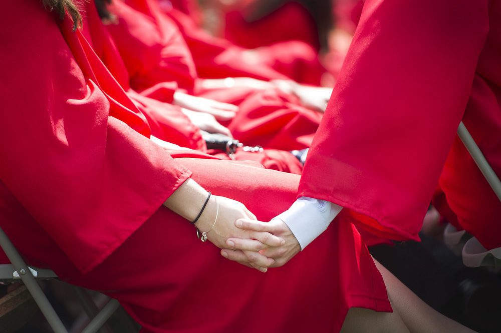 5/18/14 -- Boston, Massachusetts Anna Buggy (CAS 14) and Jason Gens (CAS 14) hold hands during the 2014 Commencement ceremony at Nickerson Field on Sunday, May 18, 2014.  Photo by Jackie Ricciardi for Boston University Photography